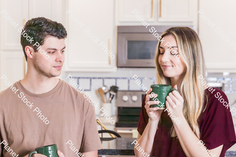 A young couple sitting and enjoying hot drinks stock photo with image ID: a3aa2618-9276-4874-ab49-e75c29350a7c