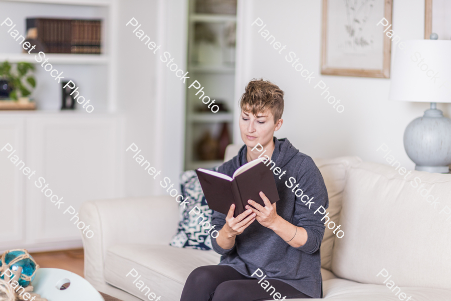 A young lady sitting on the couch stock photo with image ID: a3b1324e-4256-4ada-8653-68b94efba9c2