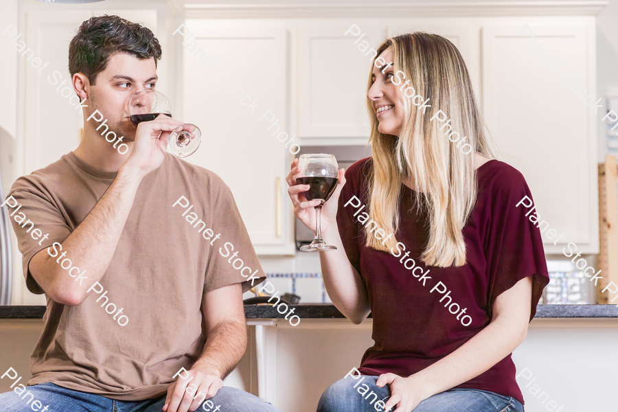 A young couple sitting and enjoying red wine stock photo with image ID: a52f3bf6-469a-4779-84a7-add750e5d29c