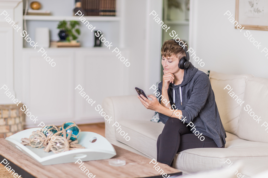 A young lady sitting on the couch stock photo with image ID: a6ac0a11-d88a-490e-ac75-a87b9e5c59db