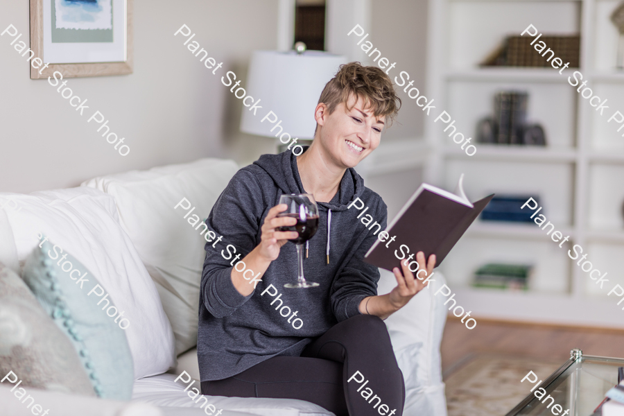 A young lady sitting on the couch stock photo with image ID: a76d62fe-4cfb-4bc0-b7c4-31554b85efe8