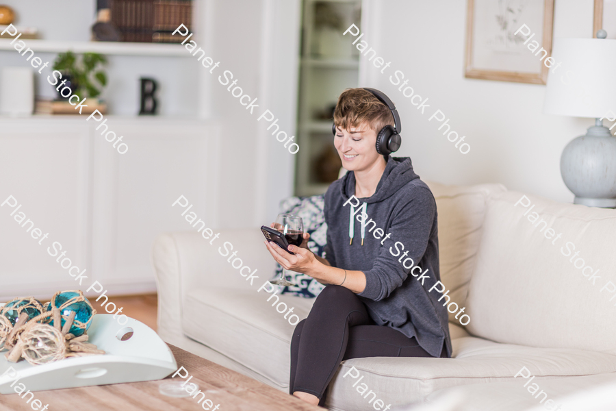 A young lady sitting on the couch stock photo with image ID: a8fddbb4-13cf-46be-b730-4c7fadca2457
