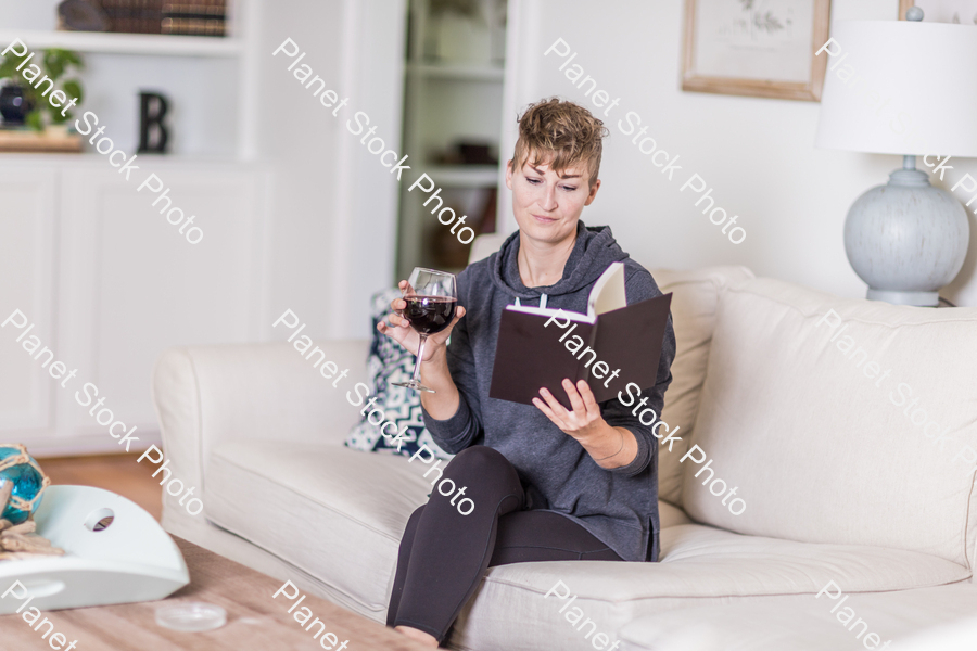 A young lady sitting on the couch stock photo with image ID: adba4287-c858-49ad-8334-b6ad29552061