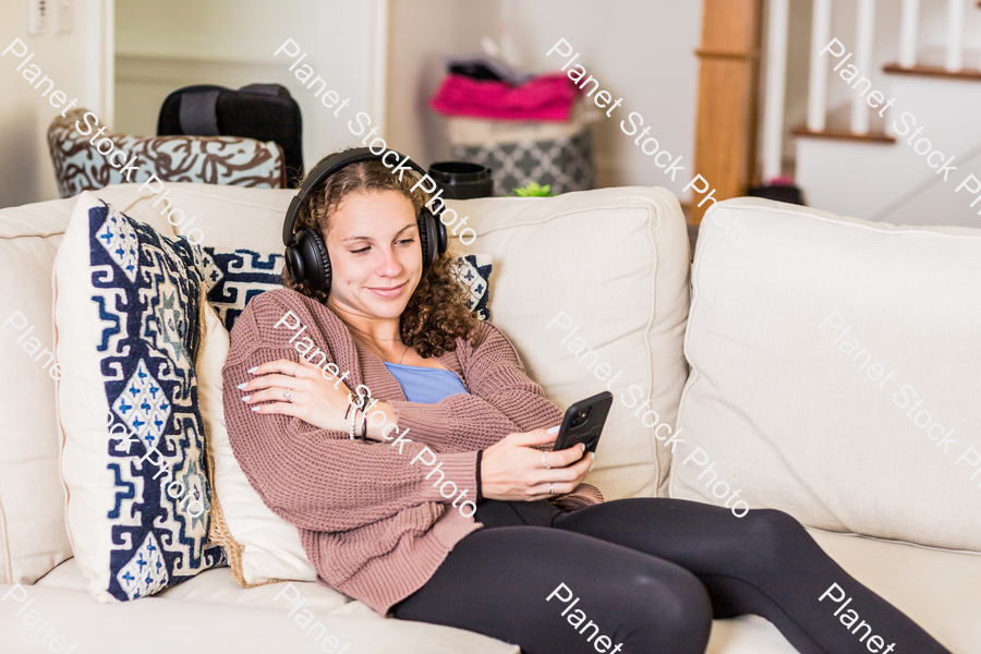 A young lady sitting on the couch stock photo with image ID: adbb28c8-8098-48e0-afa0-ae1a91f2f8f7