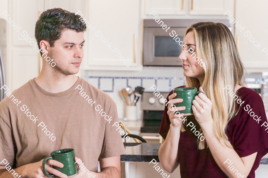 A young couple sitting and enjoying hot drinks stock photo with image ID: af9d6f8d-833d-4028-97a9-f9baa0005c45