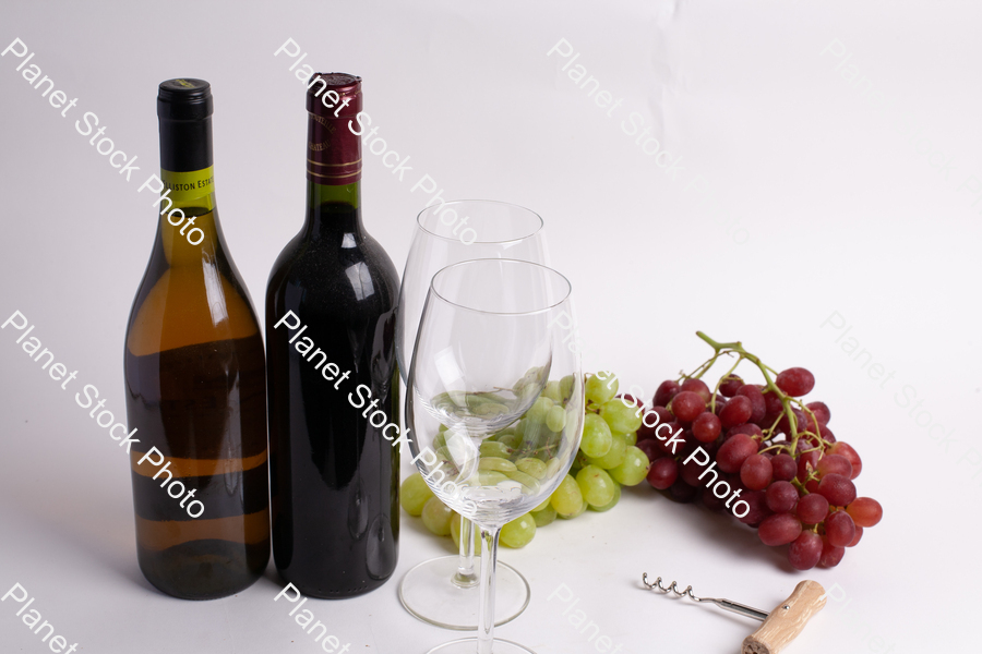 Two bottles of wine, with corkscrew, grapes, and wine glasses stock photo with image ID: b036c1c0-f414-4fa4-af7b-20be0d7e516f