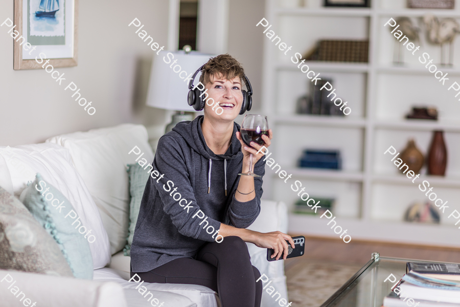 A young lady sitting on the couch stock photo with image ID: b32c7a7b-dae5-4c60-9122-a75c806bc130