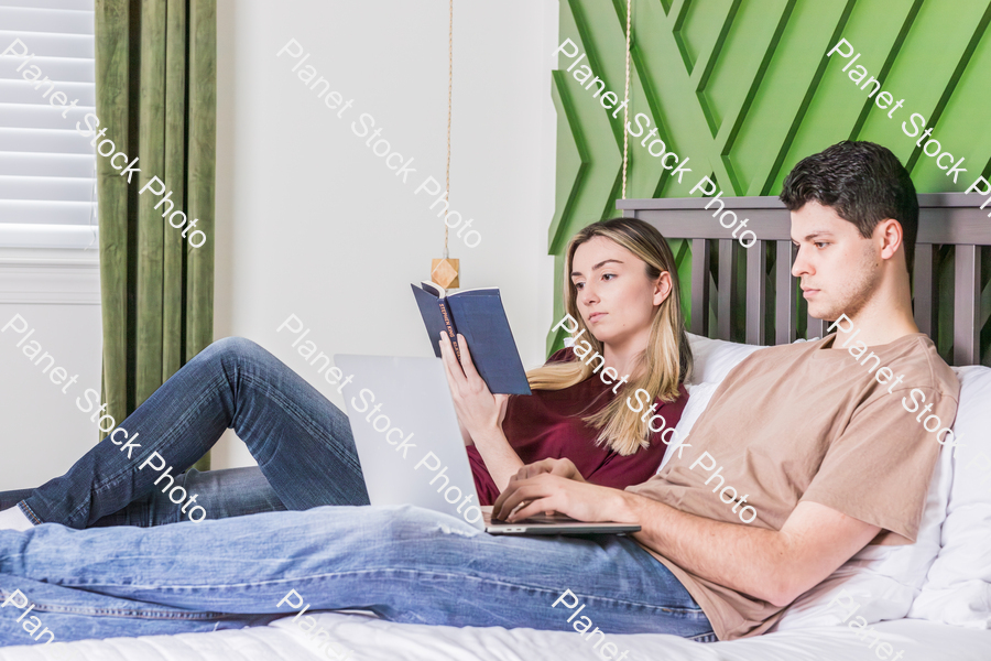 A young couple sitting in bed stock photo with image ID: b5454d01-7e1b-41ed-adf2-ef952978bc4d