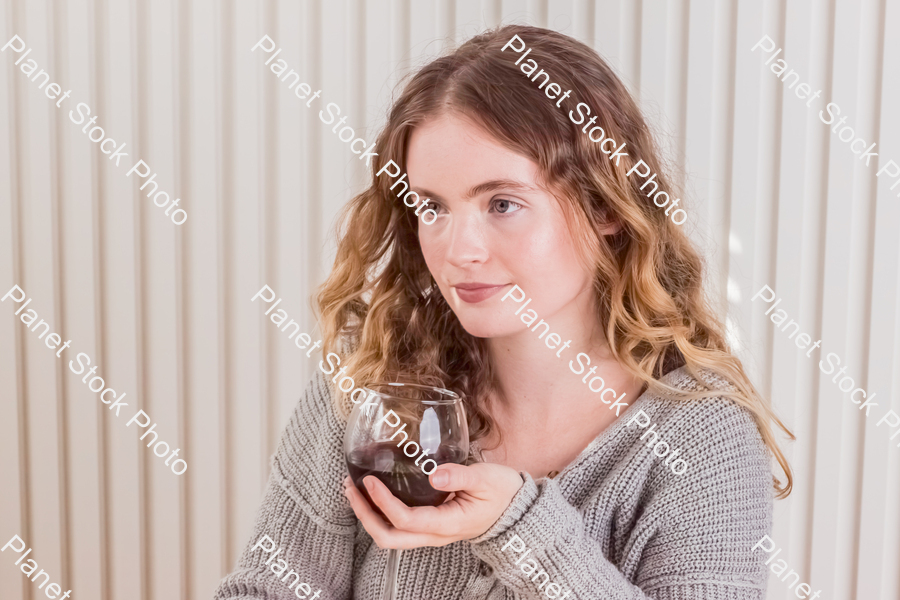A girl sitting and enjoying red wine stock photo with image ID: b5ced723-8a21-48b7-bb00-a18ddfae249a