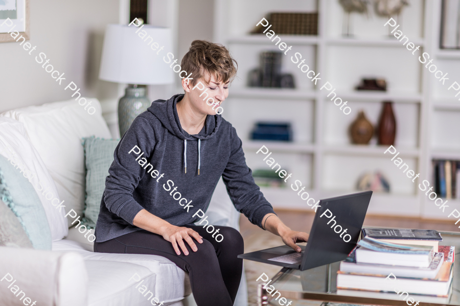 A young lady sitting on the couch stock photo with image ID: b811813c-4d84-4d61-9f0e-adfc70cecb5e