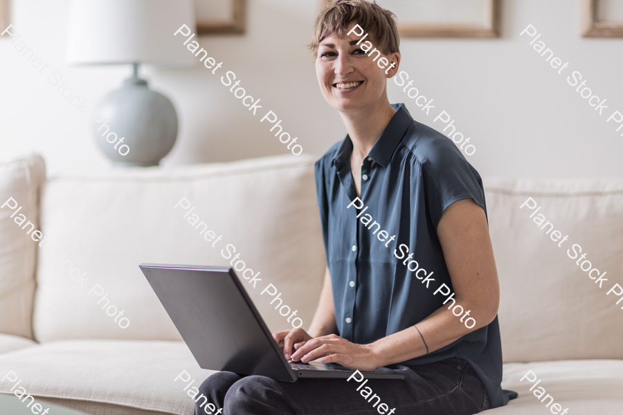 A young lady sitting on the couch stock photo with image ID: bc4e569c-5afd-41af-99aa-4b7566803fe6