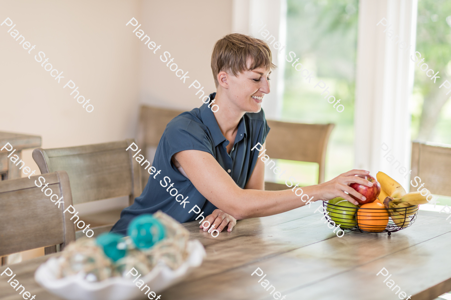 A young lady grabbing fruit stock photo with image ID: bcdc83d5-6833-4490-94c9-6d04f523329f