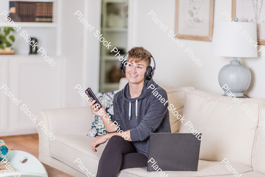 A young lady sitting on the couch stock photo with image ID: bcee103e-8008-4f83-b2dc-a7b7db3ad5b6