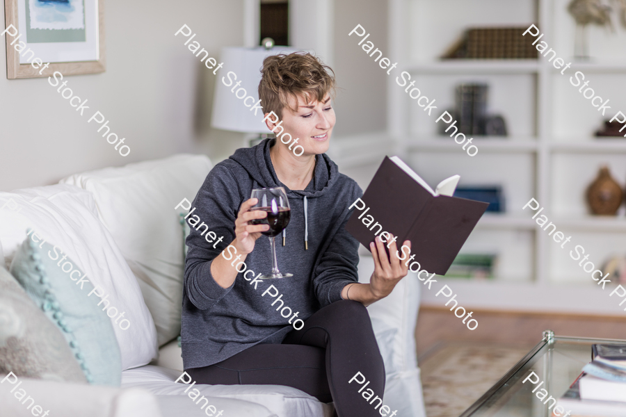 A young lady sitting on the couch stock photo with image ID: bfcb3c87-483c-490a-8e6f-724a68baf2b1