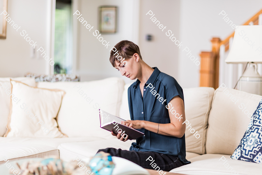 A young lady sitting on the couch stock photo with image ID: c06f234d-7cf7-45aa-9ec1-3502b0eaedcf