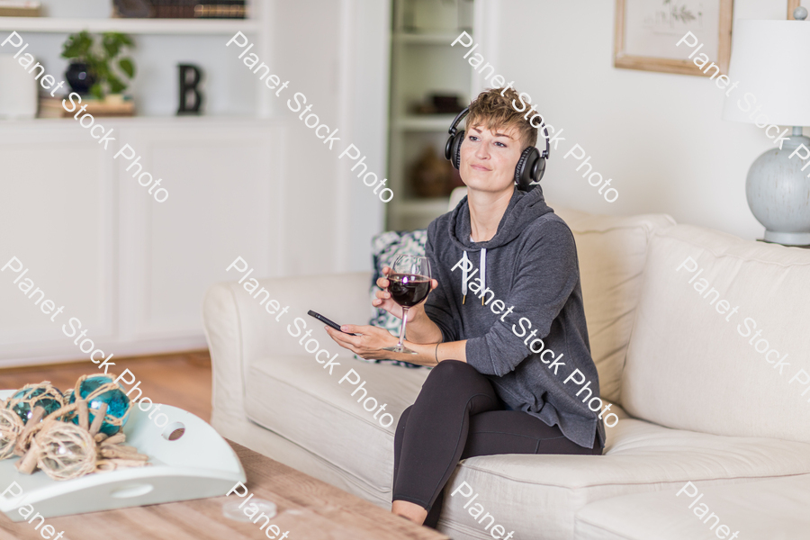 A young lady sitting on the couch stock photo with image ID: c15ee90d-411e-4312-8eba-737498bf2716