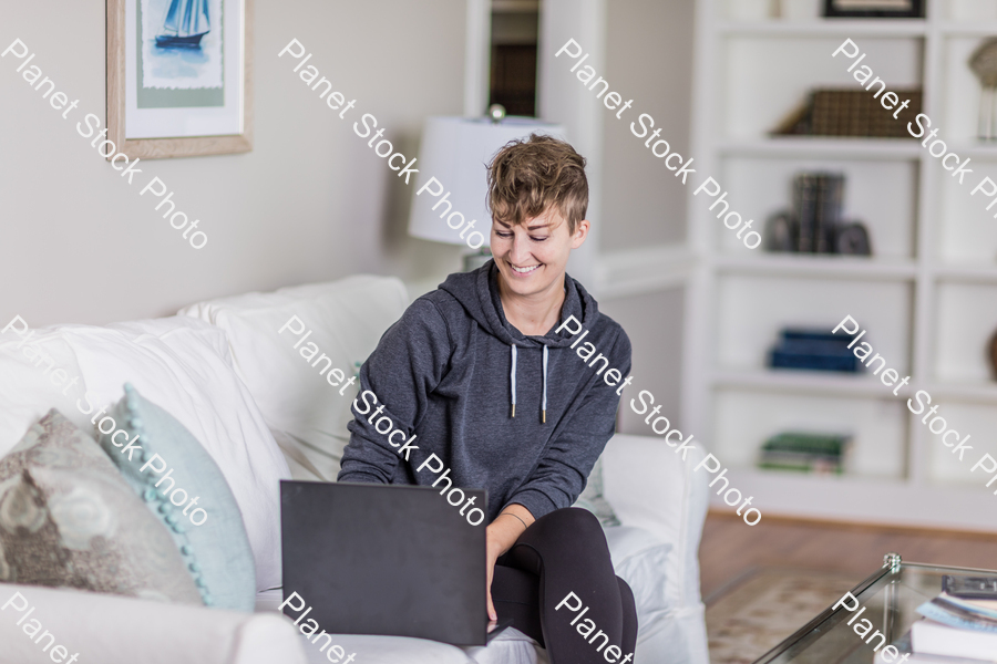 A young lady sitting on the couch stock photo with image ID: c2e5aa2d-75e0-4332-a40e-565cbb0d864d