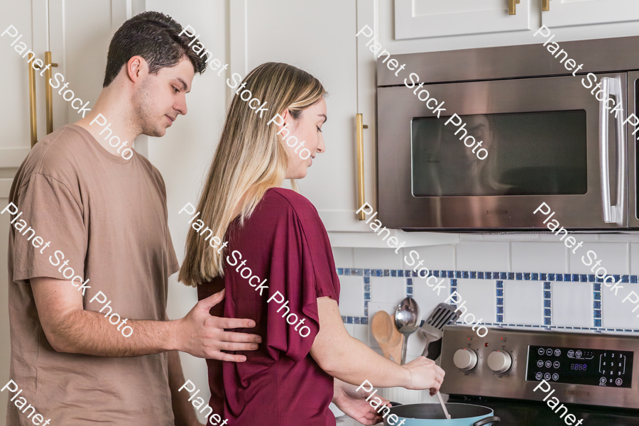 A young couple preparing a meal in the  kitchen stock photo with image ID: c486030b-ed93-4c21-aafa-23e7f930da98