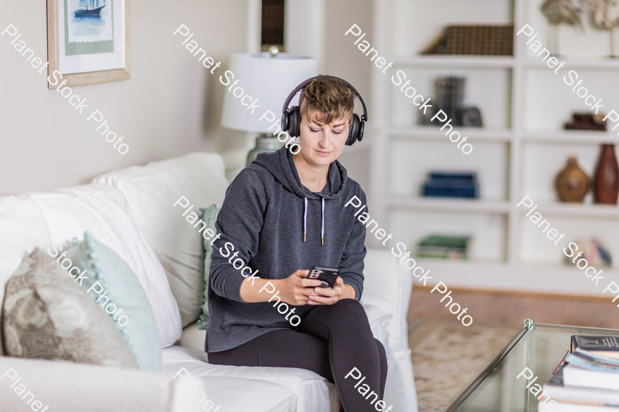 A young lady sitting on the couch stock photo with image ID: c7f2cd3b-e627-435e-ab9b-00d9c89ee824