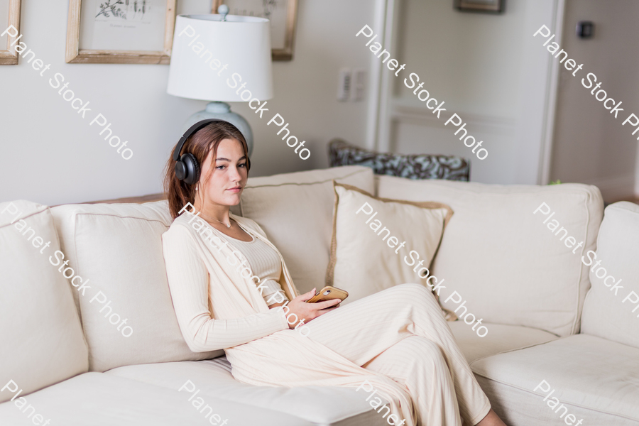 A young lady sitting on the couch stock photo with image ID: c9b29517-c1ef-4933-b4c1-1fcd86338eaa