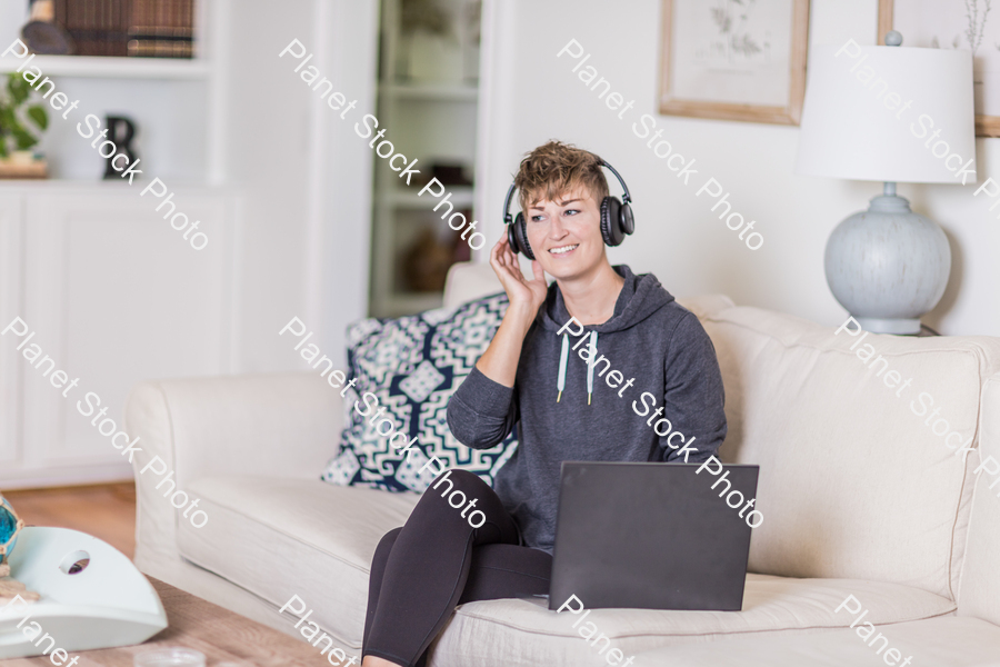 A young lady sitting on the couch stock photo with image ID: cb143bef-0a0b-4b49-aed2-9e902cb3e30f