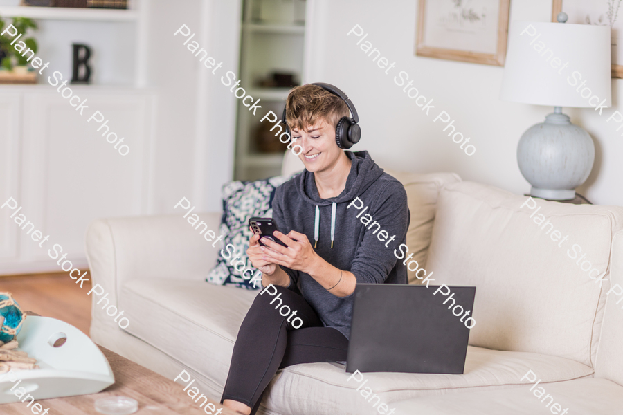 A young lady sitting on the couch stock photo with image ID: cd18d391-ca11-4fd6-96b3-1036866b4d42