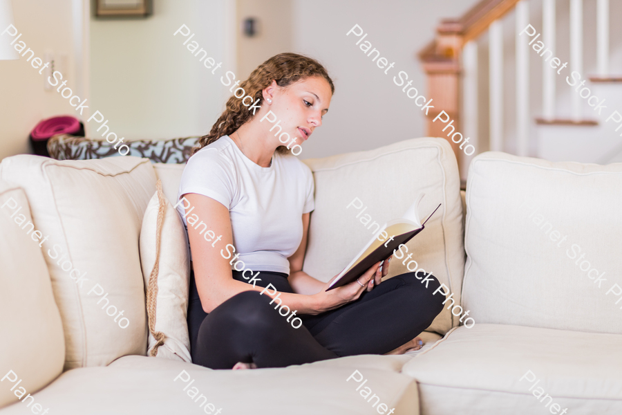 A young lady sitting on the couch stock photo with image ID: ce803b1b-7d95-480d-b102-5a0a71c97ff6