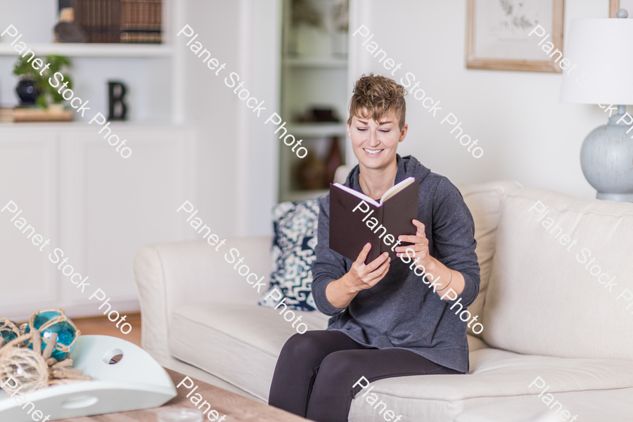 A young lady sitting on the couch stock photo with image ID: cf1eb4b2-e82f-4707-ac78-0860547fcdd5