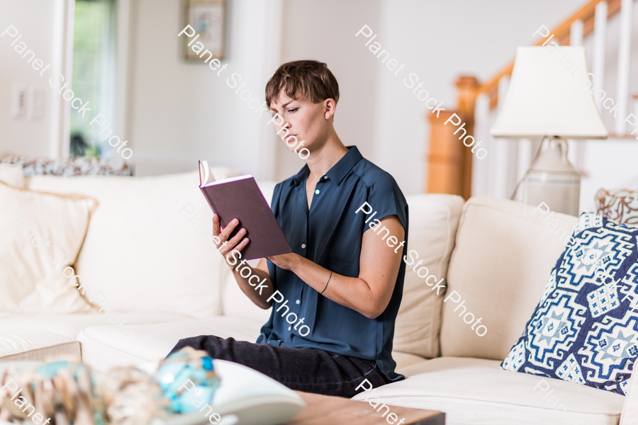 A young lady sitting on the couch stock photo with image ID: d1ec4bab-1364-4040-8944-f664f48f8378