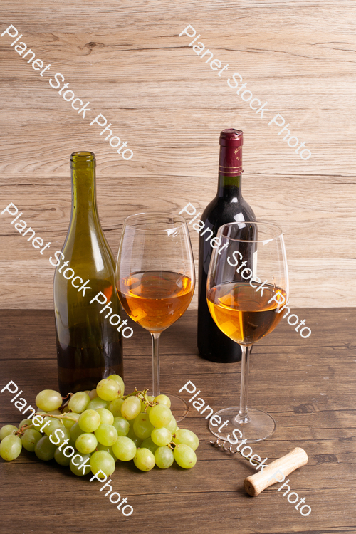 Two bottles of wine, with corkscrew, grapes, and wine glasses stock photo with image ID: d29f06b0-4818-4308-9e67-5056166b6930