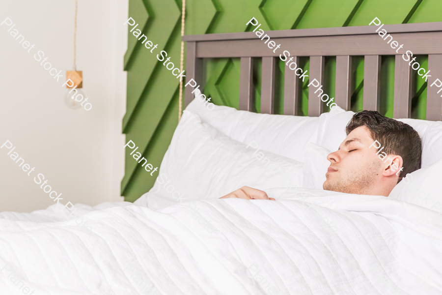 A young man sleeping in bed stock photo with image ID: d422f6d1-3d67-40a8-a9e7-7096f6a3eb50