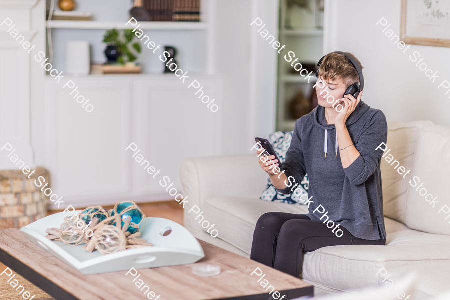 A young lady sitting on the couch stock photo with image ID: d567e7f7-9d6c-4938-b68f-7d1123607d11