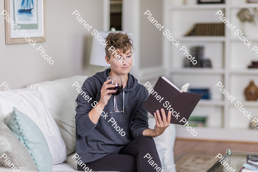 A young lady sitting on the couch stock photo with image ID: d9e44b62-0ba3-4455-8616-c0da0516287f