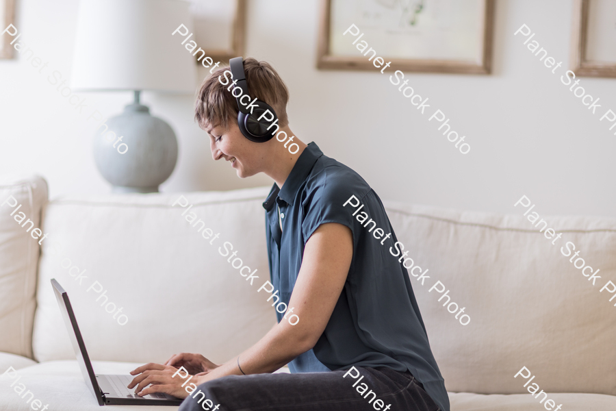 A young lady sitting on the couch stock photo with image ID: db9e48f2-be0c-4b0a-9e9d-28606971f7d0