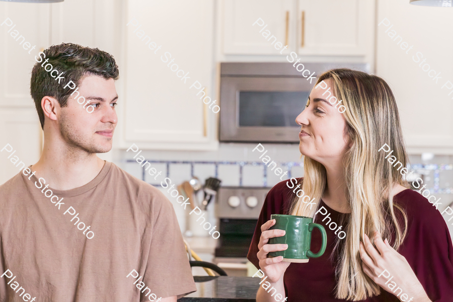 A young couple sitting and enjoying hot drinks stock photo with image ID: dcd4c037-0db4-435e-9c86-2a4cda86fd55