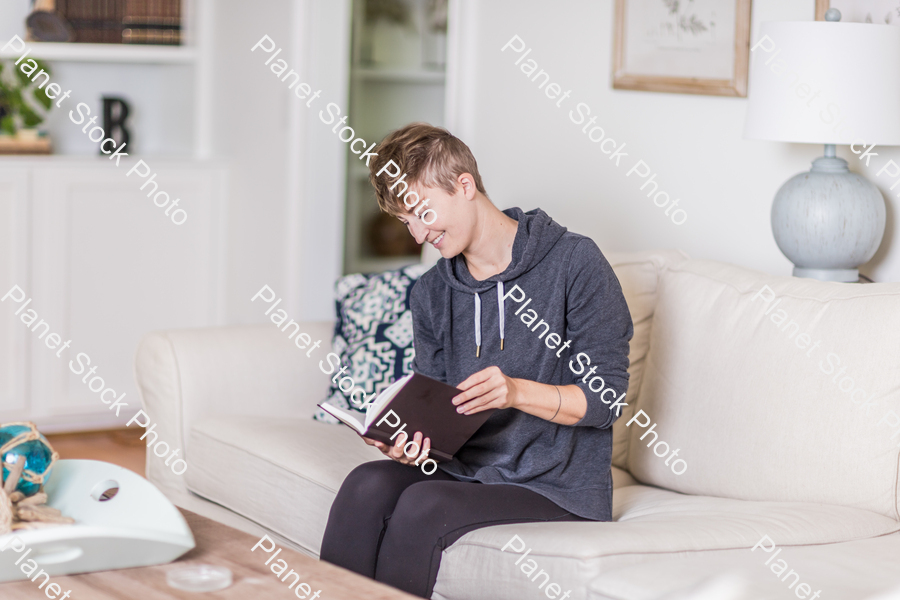 A young lady sitting on the couch stock photo with image ID: de2c053a-e629-410d-8566-12386dc99550