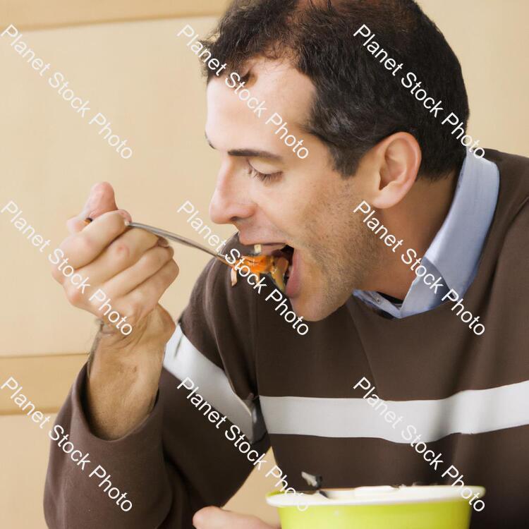 A Man Eating Food stock photo with image ID: de7d9339-9476-4ec4-aaaa-d602ccc40be1