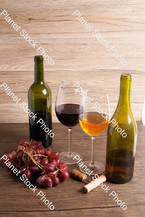 Two bottles of wine, with corkscrew, grapes, and wine glasses stock photo with image ID: df85d67f-8e6f-4015-9312-8bc5f9e1766e