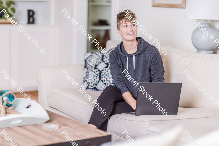 A young lady sitting on the couch stock photo with image ID: e11b31f6-5d0c-486a-a78d-15865c645884