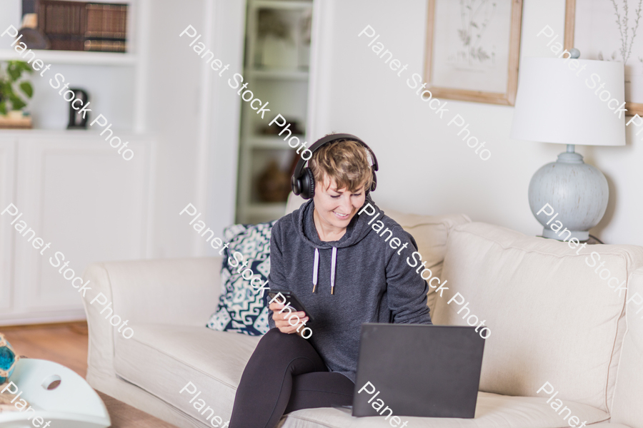 A young lady sitting on the couch stock photo with image ID: e1438d1e-0342-4047-a95d-fb637837f024