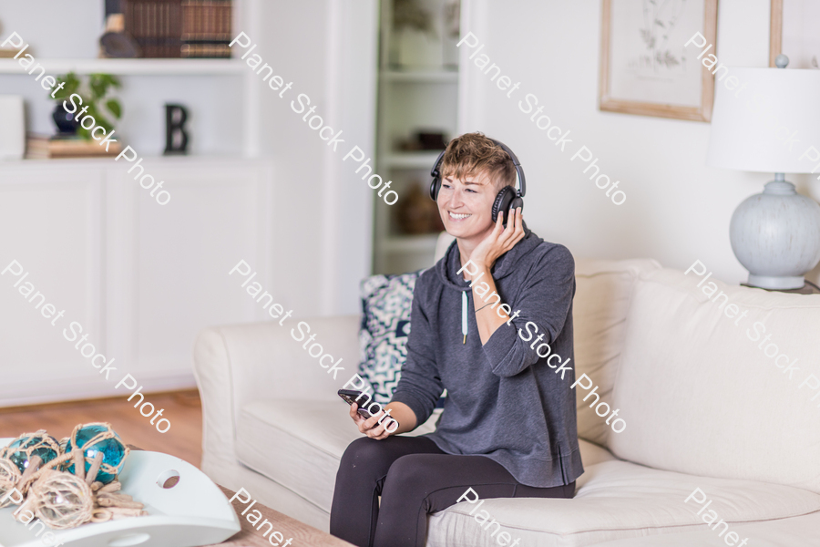 A young lady sitting on the couch stock photo with image ID: e17e80ce-13d4-4569-85a5-9fdd1a2df9c9