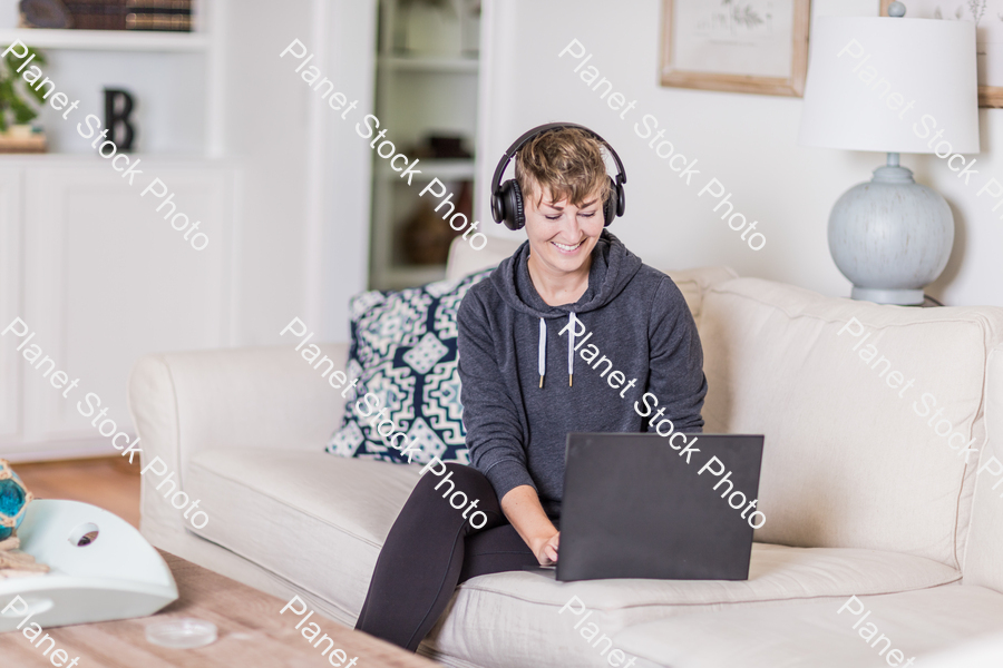 A young lady sitting on the couch stock photo with image ID: e35150ac-accf-4d80-970e-94985cb75bb0