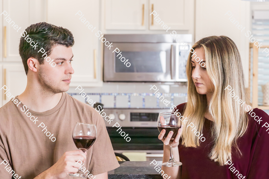 A young couple sitting and enjoying red wine stock photo with image ID: e393a3ac-5781-4e9d-8fc8-0b155fba7be4