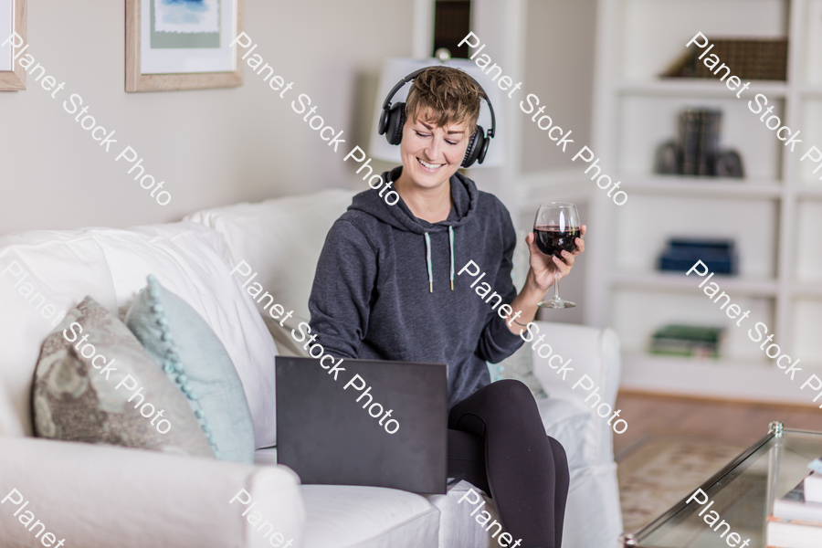 A young lady sitting on the couch stock photo with image ID: e6343cbe-5c1c-441e-9d59-b78bbdd82352