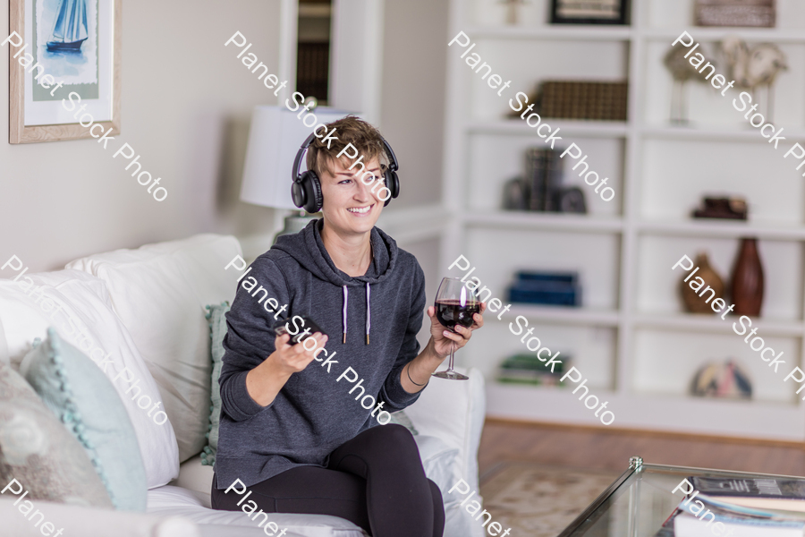 A young lady sitting on the couch stock photo with image ID: e665cbda-efb1-4542-b7b4-ee9765730488