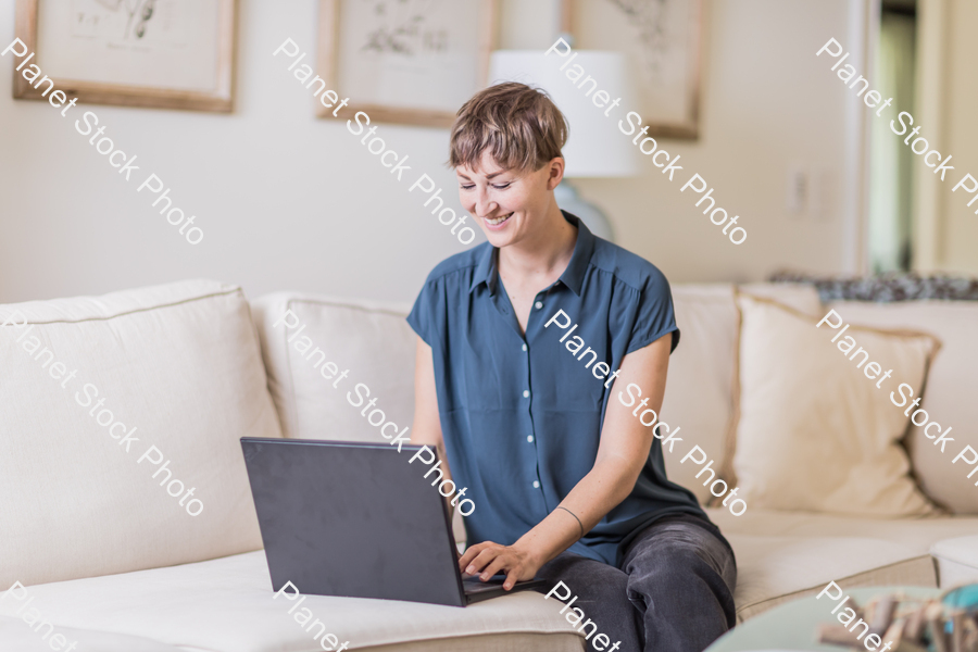 A young lady sitting on the couch stock photo with image ID: e9a4f3dd-461a-4c7e-8254-c8d16f5016c7