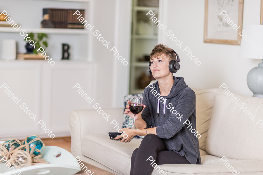 A young lady sitting on the couch stock photo with image ID: ea4fd469-f19c-4b83-93c4-40ee8bc36656