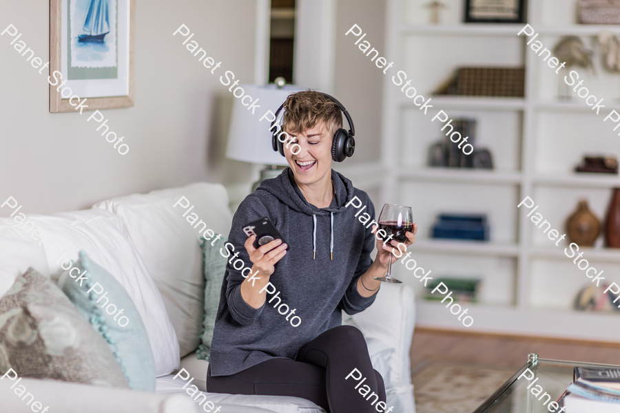 A young lady sitting on the couch stock photo with image ID: ead53a15-7ece-4fa0-b995-6c6a764a56cd