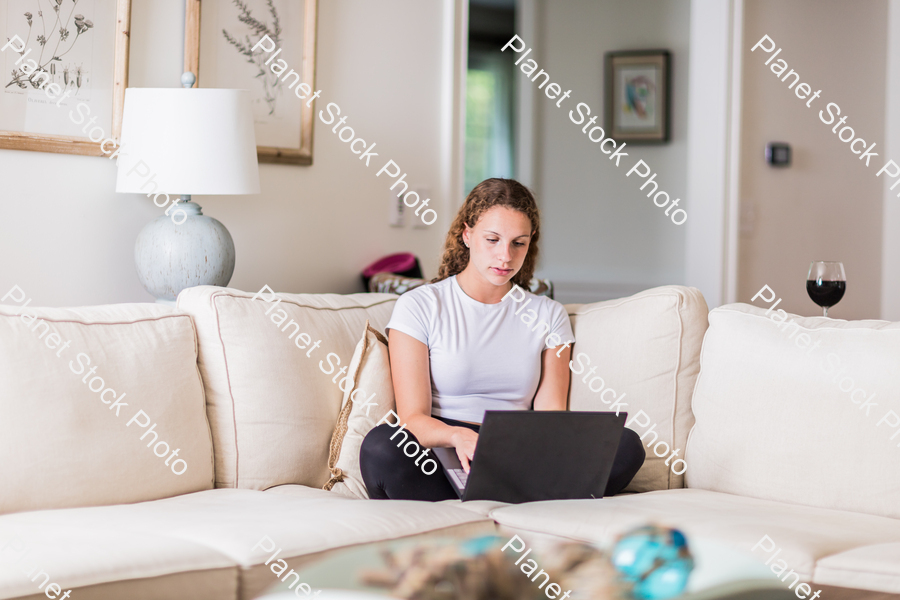 A young lady sitting on the couch stock photo with image ID: eddc6084-def2-457e-9a83-9988d4835bc5