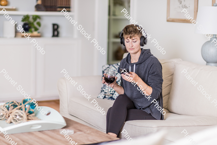 A young lady sitting on the couch stock photo with image ID: ef9c0a8a-8ad0-492e-bacd-cfb2702549c4